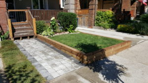 Landscape installation including walkway (interlock), lumber retaining wall and a new garden